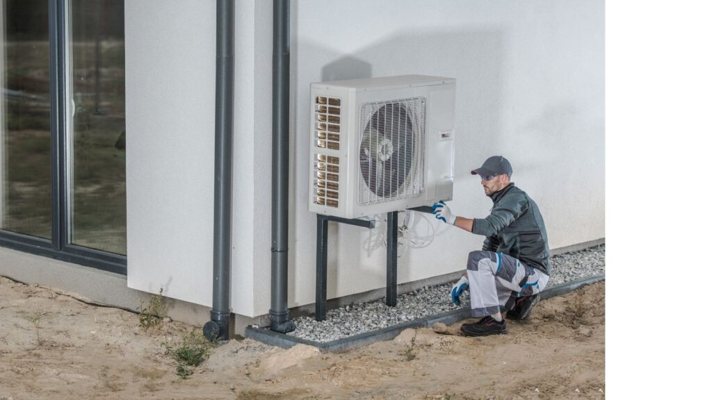 Mies asentamassa ilmavesilämpöpumppua.